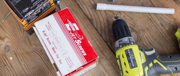 green Ryobi hand drill near white and red box